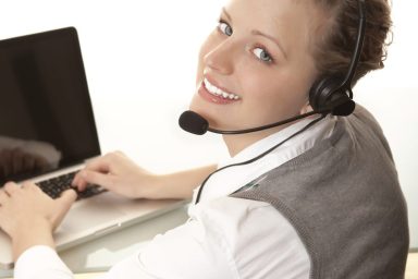 Customer service person wearing a headset in front of their computer